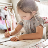 Child working on their personalized workbook. The child is filling out the calendar page and tracing their name.